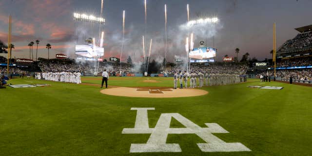 Oct. 9, 2015: Members of the Los Angeles Dodgers, left, and the New York Mets line up before the start of Game 1 of baseball's National League Division Series in Los Angeles.