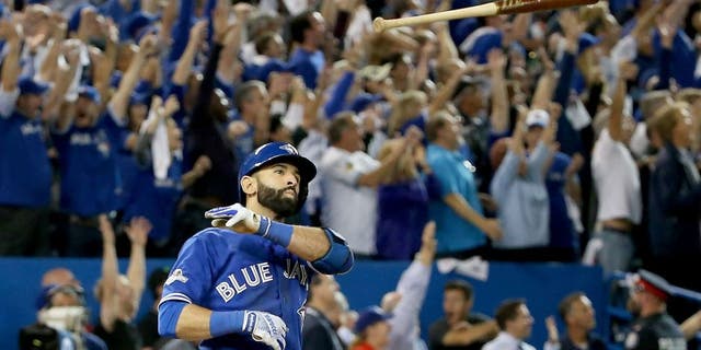 TORONTO, ON - OCTOBER 14: Jose Bautista #19 of the Toronto Blue Jays throws his bat up in the air after he hits a three-run home run in the seventh inning against the Texas Rangers in game five of the American League Division Series at Rogers Centre on October 14, 2015 in Toronto, Canada. (Photo by Tom Szczerbowski/Getty Images)