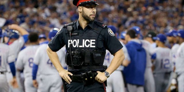 TORONTO, ON - OCTOBER 14: As the benches clear a Toronto police officer is seen in game five of the American League Division Series between the Texas Rangers and the Toronto Blue Jays at Rogers Centre on October 14, 2015 in Toronto, Canada. (Photo by Tom Szczerbowski/Getty Images)