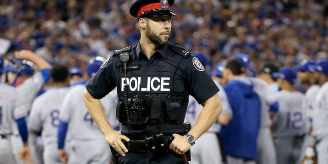 TORONTO, ON - OCTOBER 14: As the benches clear a Toronto police officer is seen in game five of the American League Division Series between the Texas Rangers and the Toronto Blue Jays at Rogers Centre on October 14, 2015 in Toronto, Canada. (Photo by Tom Szczerbowski/Getty Images)