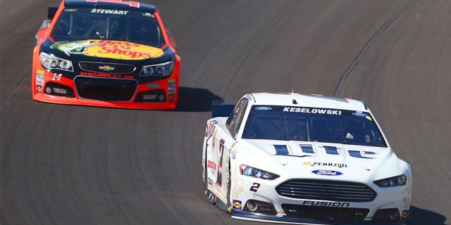 Jun 15, 2014; Brooklyn, MI, USA; NASCAR Sprint Cup Series driver Brad Keselowski leads Tony Stewart during the Quicken Loans 400 at Michigan International Speedway. Mandatory Credit: Andrew Weber-USA TODAY Sports