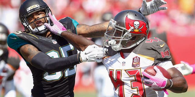 Oct 11, 2015; Tampa, FL, USA; Jacksonville Jaguars cornerback Demetrius McCray (35)is stiff armed by Tampa Bay Buccaneers running back Bobby Rainey (43) during the second quarter of an NFL football game at Raymond James Stadium. Mandatory Credit: Reinhold Matay-USA TODAY Sports