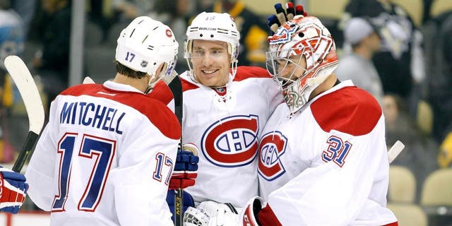 PITTSBURGH, PA - OCTOBER 13: Carey Price #31 of the Montreal Canadiens celebrates with Tomas Fleischmann #15 and Torrey Mitchell #17 after defeating the Pittsburgh Penguins 3-2 at Consol Energy Center on October 13, 2015 in Pittsburgh, Pennsylvania. (Photo by Justin K. Aller/Getty Images)