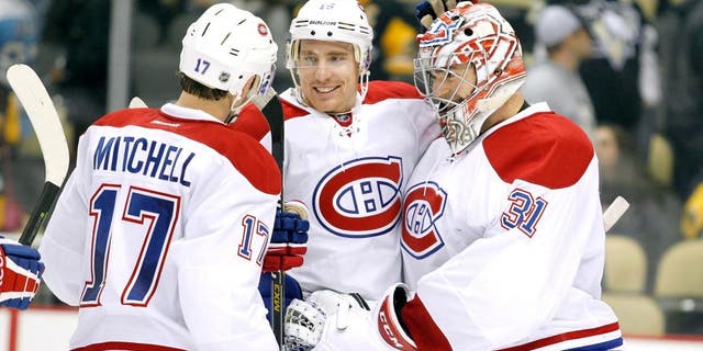 PITTSBURGH, PA - OCTOBER 13: Carey Price #31 of the Montreal Canadiens celebrates with Tomas Fleischmann #15 and Torrey Mitchell #17 after defeating the Pittsburgh Penguins 3-2 at Consol Energy Center on October 13, 2015 in Pittsburgh, Pennsylvania. (Photo by Justin K. Aller/Getty Images)