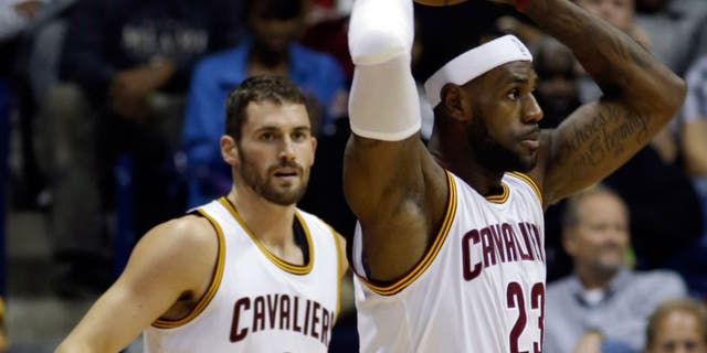 Cleveland Cavaliers forward LeBron James (23) looks to pass against the Indiana Pacers in the first half of an NBA preseason basketball game, Wednesday, Oct. 15, 2014, in Cincinnati. Cavaliers forward Kevin Love (0) watches. (AP Photo/Al Behrman)