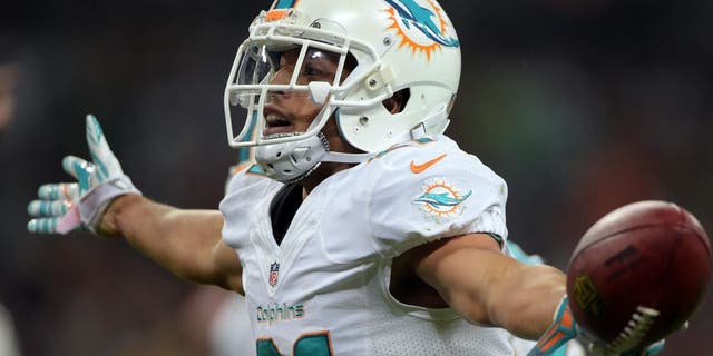 Sep 28, 2014; London, UNITED KINGDOM; Miami Dolphins cornerback Brent Grimes (21) celebrates after an interception against the Oakland Raiders in the NFL International Series game at Wembley Stadium. The Dolphins defeated the Raiders 38-14. Mandatory Credit: Kirby Lee-USA TODAY Sports