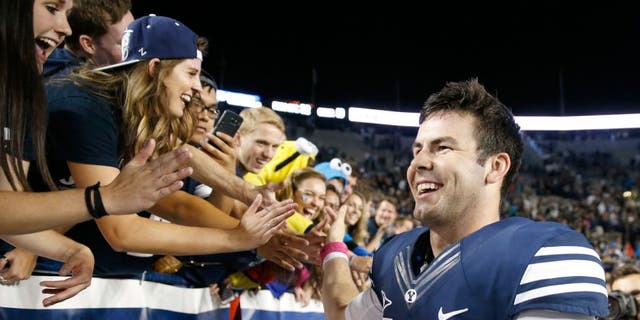 Oct 16, 2015; Provo, UT, USA; Brigham Young Cougars quarterback Tanner Mangum (12) greets fans after their 38-24 win against the Cincinnati Bearcats at Lavell Edwards Stadium. Mandatory Credit: Jeff Swinger-USA TODAY Sports