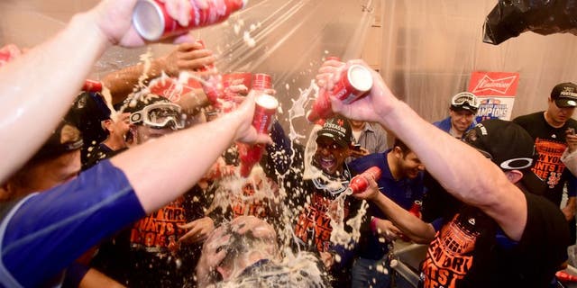 LOS ANGELES, CA - OCTOBER 15: The New York Mets celebrate in the locker room after the Mets 3-2 victory against the Los Angeles Dodgers in game five of the National League Division Series at Dodger Stadium on October 15, 2015 in Los Angeles, California. (Photo by Harry How/Getty Images)