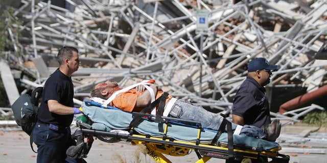 Oct. 16, 2015: Emergency personnel tend to an injured worker at a scaffolding collapse at a building under construction in Houston.