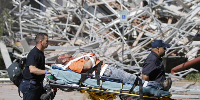 Oct. 16, 2015: Emergency personnel tend to an injured worker at a scaffolding collapse at a building under construction in Houston.