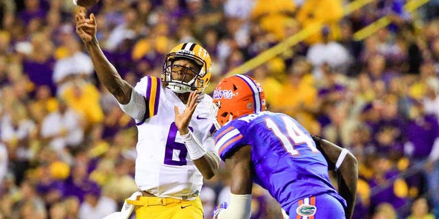 Oct 17, 2015; Baton Rouge, LA, USA; LSU Tigers quarterback Brandon Harris (6) throws as Florida Gators defensive lineman Alex McCalister (14) defends during the second quarter of a game at Tiger Stadium. Mandatory Credit: Derick E. Hingle-USA TODAY Sports