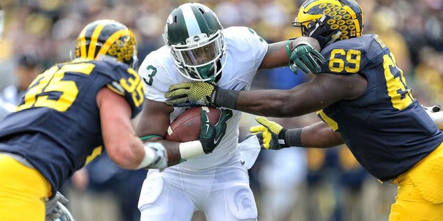 Oct 17, 2015; Ann Arbor, MI, USA; Michigan State Spartans running back LJ Scott (3) carries the ball between Michigan Wolverines linebacker Joe Bolden (35) and Michigan Wolverines defensive tackle Willie Henry (69) during the 1st quarter of a game at Michigan Stadium. Mandatory Credit: Mike Carter-USA TODAY Sports
