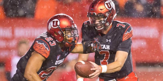 Oct 17, 2015; Salt Lake City, UT, USA; Utah Utes quarterback Travis Wilson (7) hands off to running back Devontae Booker (23) during the first half against the Arizona State Sun Devils at Rice-Eccles Stadium. Mandatory Credit: Russ Isabella-USA TODAY Sports
