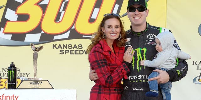 KANSAS CITY, KS - OCTOBER 17: Kyle Busch, driver of the #54 Monster Energy Toyota, poses in Victory Lane with his wife, Samantha, and son, Brexton during the NASCAR XFINITY Series Kansas Lottery 300 at Kansas Speedway on October 17, 2015 in Kansas City, Kansas. (Photo by Robert Laberge/NASCAR via Getty Images)