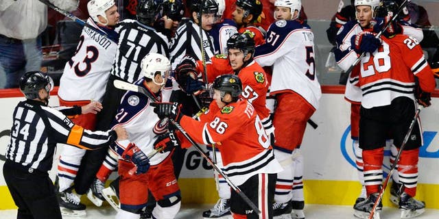 Chicago Blackhawks players scuffle with Columbus Blue Jackets players during the third period of an NHL hockey game Saturday, Oct. 17, 2015, in Chicago. Chicago won 4-1. (AP Photo/Paul Beaty)