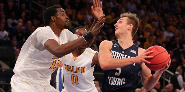 Mar 29, 2016; New York, NY, USA; BYU Cougars guard Kyle Collinsworth (5) prepares to shoot the ball as Valparaiso Crusaders center Vashil Fernandez (14) and guard Keith Carter (0) defend during the second half of a semifinal game of the 2016 NIT basketball tournament at Madison Square Garden. The Crusaders won 72-70. Mandatory Credit: Brad Penner-USA TODAY Sports