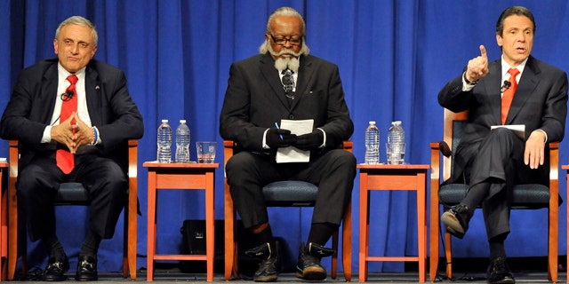 Oct. 18, 2010: Republican candidate Carl Paladino, left, listens with Rent is 2 Damn High candidate Jimmy McMillan as Democratic candidate Andrew Cuomo speaks during the 2010 New York State gubernatorial debate at Hofstra University in Hempstead, N.Y.