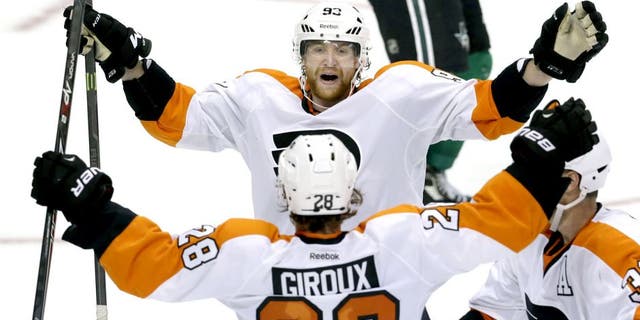 Philadelphia Flyers right wing Jakub Voracek (93) celebrates the game winning goal with teammates center Claude Giroux (28) and defenseman Mark Streit (32) during overtime of an NHL hockey game against the Dallas Stars Saturday, Oct. 18, 2014, in Dallas. The Flyers won 6-5. (AP Photo/LM Otero)