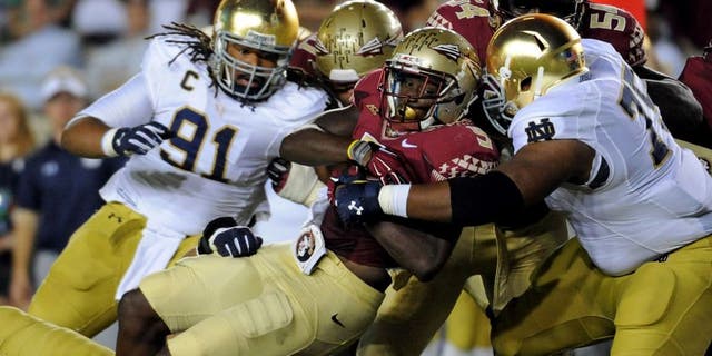 Oct 18, 2014; Tallahassee, FL, USA; Florida State Seminoles running back Karlos Williams (9) runs the ball and is tackled by Notre Dame Fighting Irish defensive lineman Daniel Cage (75) during the first half at Doak Campbell Stadium. Mandatory Credit: Melina Vastola-USA TODAY Sports
