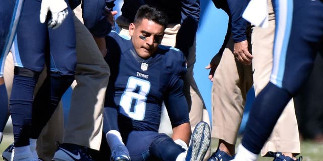 NASHVILLE, TN - OCTOBER 18: Quarterback Marcus Mariota #8 of the Tennessee Titans is attended to by medical staff after receiving a late hit by the Miami Dolphins during the first half of a game at Nissan Stadium on October 18, 2015 in Nashville, Tennessee. (Photo by Frederick Breedon/Getty Images)
