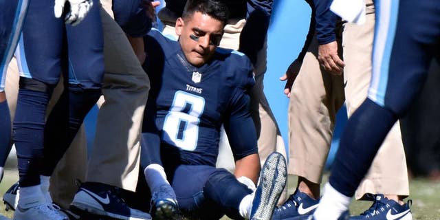 NASHVILLE, TN - OCTOBER 18: Quarterback Marcus Mariota #8 of the Tennessee Titans is attended to by medical staff after receiving a late hit by the Miami Dolphins during the first half of a game at Nissan Stadium on October 18, 2015 in Nashville, Tennessee. (Photo by Frederick Breedon/Getty Images)