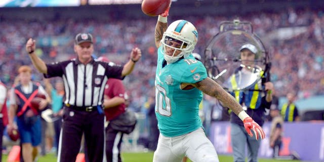 Oct 4, 2015; London, United Kingdom; Miami Dolphins receiver Kenny Stills (10) spikes the ball in celebration after scoring on a 10-yard touchdown reception in the fourth quarter against the New York Jets in Game 12 of the NFL International Series at Wembley Stadium. The Jets defeated the Dolphins 27-14. Mandatory Credit: Kirby Lee-USA TODAY Sports
