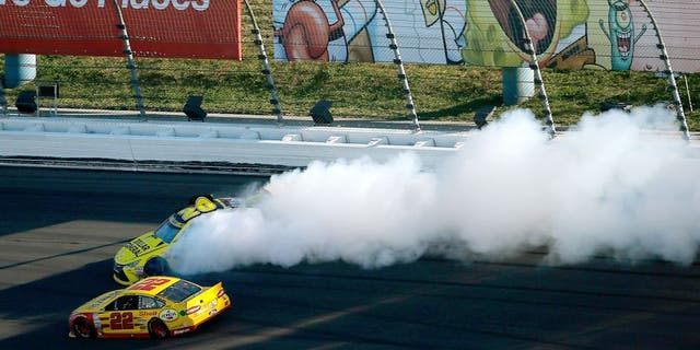 KANSAS CITY, KS - OCTOBER 18: Matt Kenseth, driver of the #20 Dollar General Toyota, spins as Joey Logano, driver of the #22 Shell Pennzoil Ford, races by during the NASCAR Sprint Cup Series Hollywood Casino 400 at Kansas Speedway on October 18, 2015 in Kansas City, Kansas. (Photo by Todd Warshaw/Getty Images)