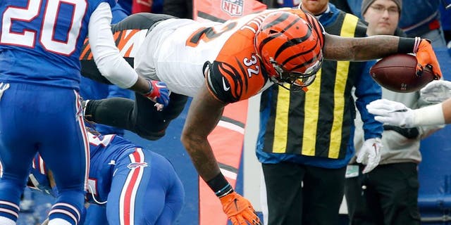 Cincinnati Bengals running back Jeremy Hill (32) dives past Buffalo Bills defenders for a touchdown during the first half of an NFL football game on Sunday, Oct. 18, 2015, in Orchard Park, N.Y. (AP Photo/Bill Wippert)