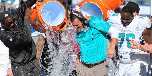 Oct 18, 2015; Nashville, TN, USA; Miami Dolphins interim head coach Dan Campbell is dumped with Gatorade after a win against the Tennessee Titans at Nissan Stadium. The Dolphins won 38-10. Mandatory Credit: Christopher Hanewinckel-USA TODAY Sports