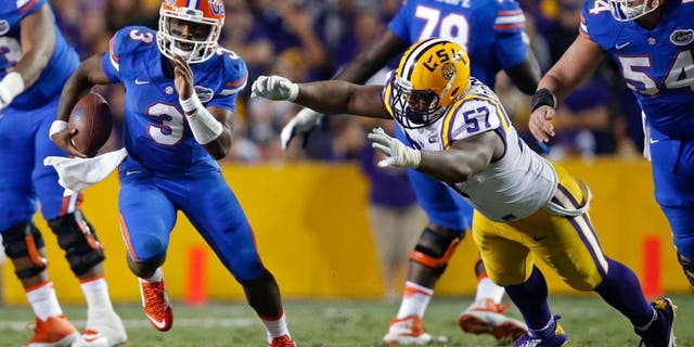 Florida quarterback Treon Harris (3) carries past LSU defensive tackle Davon Godchaux (57) in the second half of an NCAA college football game in Baton Rouge, La., Saturday, Oct. 17, 2015. LSU won 35-28. (AP Photo/Gerald Herbert)