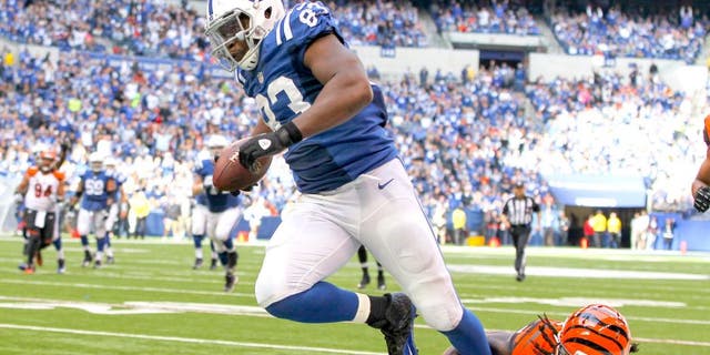 Oct 19, 2014; Indianapolis, IN, USA; Indianapolis Colts tight end Dwayne Allen (83) avoids the tackle of Cincinnati Bengals cornerback Dre Kirkpatrick (27) to score a touchdown during the third quarter at Lucas Oil Stadium. The Colts defeated the Bengals 27-0. Mandatory Credit: Pat Lovell-USA TODAY Sports