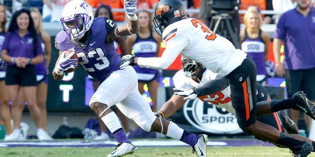 Oct 18, 2014; Fort Worth, TX, USA; TCU Horned Frogs tailback B.J. Catalon (23) runs with the ball against Oklahoma State Cowboys safety Tre Flowers (31) at Amon G. Carter Stadium. Mandatory Credit: Matthew Emmons-USA TODAY Sports