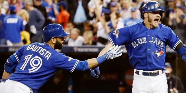 TORONTO, ON - OCTOBER 19: Josh Donaldson #20 of the Toronto Blue Jays celebrates with Jose Bautista #19 of the Toronto Blue Jays after hitting a two-run home run in the third inning against the Kansas City Royals during game three of the American League Championship Series at Rogers Centre on October 19, 2015 in Toronto, Canada. (Photo by Tom Szczerbowski/Getty Images)