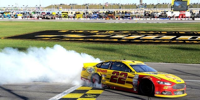 KANSAS CITY, KS - OCTOBER 18: Joey Logano, driver of the #22 Shell Pennzoil Ford, celebrates with a burnout after winning the NASCAR Sprint Cup Series Hollywood Casino 400 at Kansas Speedway on October 18, 2015 in Kansas City, Kansas. (Photo by Ed Zurga/Getty Images)
