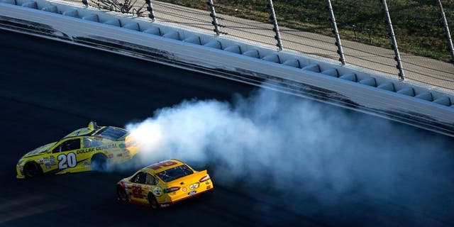 KANSAS CITY, KS - OCTOBER 18: Matt Kenseth, driver of the #20 Dollar General Toyota, spins as Joey Logano, driver of the #22 Shell Pennzoil Ford, races by during the NASCAR Sprint Cup Series Hollywood Casino 400 at Kansas Speedway on October 18, 2015 in Kansas City, Kansas. (Photo by Todd Warshaw/Getty Images)