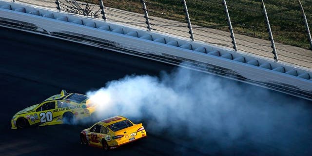 KANSAS CITY, KS - OCTOBER 18: Matt Kenseth, driver of the #20 Dollar General Toyota, spins as Joey Logano, driver of the #22 Shell Pennzoil Ford, races by during the NASCAR Sprint Cup Series Hollywood Casino 400 at Kansas Speedway on October 18, 2015 in Kansas City, Kansas. (Photo by Todd Warshaw/Getty Images)