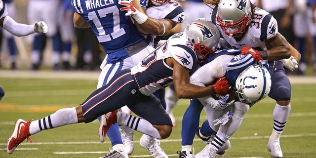 INDIANAPOLIS - OCTOBER 18: New England Patriots Brandon Bolden and New England Patriots defense weren't fooled when the Indianapolis Colts lined up in a strange punt formation as Bolden and cornerback Logan Ryan grabbed Indianapolis Colts Colt Anderson and took him to the turf on the play in the third quarter. The New England Patriots take on the Indianapolis Colts in a Sunday night football game at Lucas Oil Stadium in Indianapolis, Ind. on Oct. 18, 2015. (Photo by Barry Chin/The Boston Globe via Getty Images)