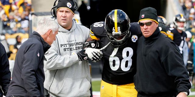 In this Sunday, Oct. 18, 2015, photo, Pittsburgh Steelers tackle Kelvin Beachum (68) is helped from the field by quarterback Ben Roethlisberger, center left, towards Steelers head athletic trainer John Norwig, left, after he was injured in the NFL football game against the Arizona Cardinals in Pittsburgh. Beachum did not return to the game. The Steelers announced Monday, Oct. 19, that they placed Beachum on the Reserve/Injured List and signed offensive tackle Byron Stingily. (AP Photo/Gene J. Puskar)