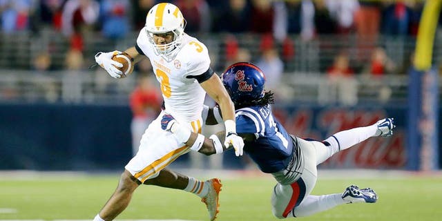 Oct 18, 2014; Oxford, MS, USA; Tennessee Volunteers wide receiver Josh Malone (3) is tackled by Mississippi Rebels defensive back Trae Elston (7) during the game at Vaught-Hemingway Stadium. The Mississippi Rebels defeated the Tennessee Volunteers 34-3. Mandatory Credit: Spruce Derden-USA TODAY Sports