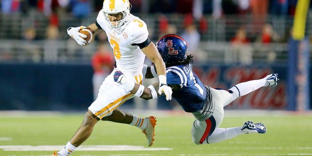 Oct 18, 2014; Oxford, MS, USA; Tennessee Volunteers wide receiver Josh Malone (3) is tackled by Mississippi Rebels defensive back Trae Elston (7) during the game at Vaught-Hemingway Stadium. The Mississippi Rebels defeated the Tennessee Volunteers 34-3. Mandatory Credit: Spruce Derden-USA TODAY Sports