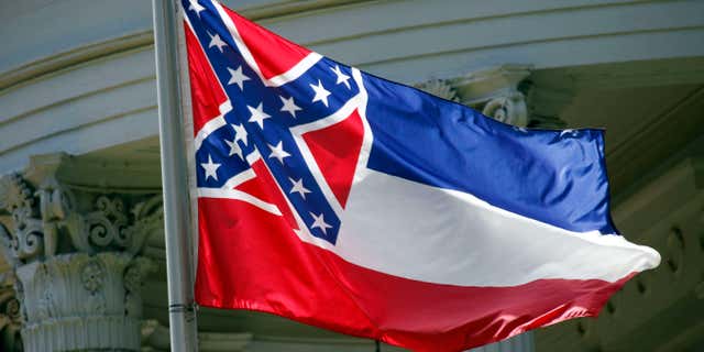 In this photo taken June 23, 2015, the Mississippi state flag is unfurled against the front of the Governor's Mansion in Jackson, Miss.