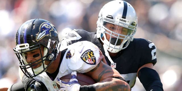 OAKLAND, CA - SEPTEMBER 20: Crockett Gillmore #80 of the Baltimore Ravens carries for a touchdown against the block of Taylor Mays #27 of the Oakland Raiders in the second quarter against the Oakland Raiders at Oakland-Alameda County Coliseum on September 20, 2015 in Oakland, California. (Photo by Ezra Shaw/Getty Images)