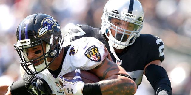 OAKLAND, CA - SEPTEMBER 20: Crockett Gillmore #80 of the Baltimore Ravens carries for a touchdown against the block of Taylor Mays #27 of the Oakland Raiders in the second quarter against the Oakland Raiders at Oakland-Alameda County Coliseum on September 20, 2015 in Oakland, California. (Photo by Ezra Shaw/Getty Images)