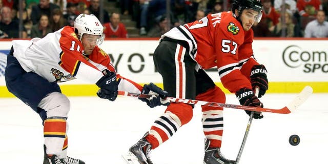 Florida Panthers left wing Jonathan Huberdeau, left, and Chicago Blackhawks defenseman Trevor van Riemsdyk battle for the puck during the first period of an NHL hockey game Thursday, Oct. 22, 2015, in Chicago. (AP Photo/Nam Y. Huh)