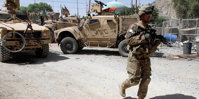 File: June 19, 2012: A US soldier, part of the NATO forces, patrols a police station in Kandahar, south of Kabul, Afghanistan.