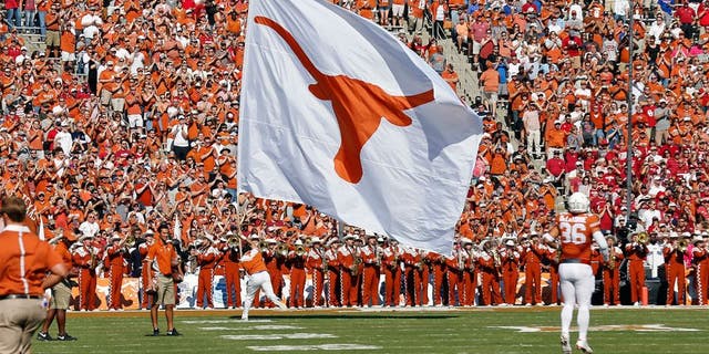 Oct 10, 2015; Dallas, TX, USA; Texas Longhorns cheerleader carries a Texas flag against the Oklahoma Sooners during Red River rivalry at Cotton Bowl Stadium. Mandatory Credit: Matthew Emmons-USA TODAY Sports