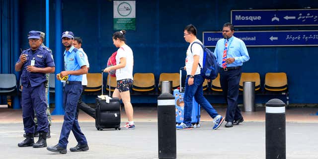 Oct. 24, 2015: Police prepare to cordon off an area before the arrival of Vice President Ahmed Adheeb at the International Airport in Male, Maldives.