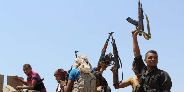 Oct. 2, 2015: Fighters against Shiite rebels known as Houthis hold up their weapons as they ride on an armored vehicle near the strait of Bab al-Mandab, west of the southern port city of Aden, to take back the control of the strait, Yemen.
