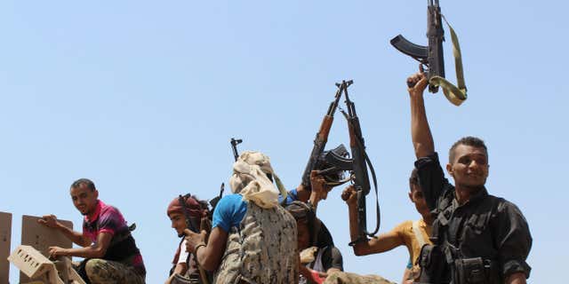 Oct. 2, 2015: Fighters against Shiite rebels known as Houthis hold up their weapons as they ride on an armored vehicle near the strait of Bab al-Mandab, west of the southern port city of Aden, to take back the control of the strait, Yemen.