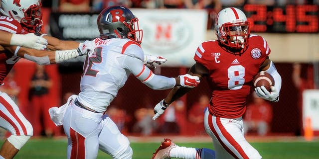 LINCOLN, NE - OCTOBER 25: Running back Ameer Abdullah #8 of the Nebraska Cornhuskers runs past defensive back Nadir Barnwell #12 of the Rutgers Scarlet Knights during their game at Memorial Stadium on October 25, 2014 in Lincoln, Nebraska. (Photo by Eric Francis/Getty Images)